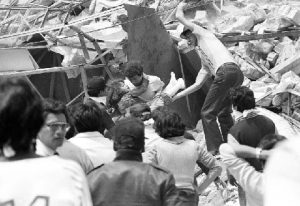 A rescue worker carries an injured child from an earthquake damaged building in Mexico City