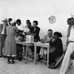 A Haitian woman voter dips the little finger of her right hand in indelible ink before casting her ballot