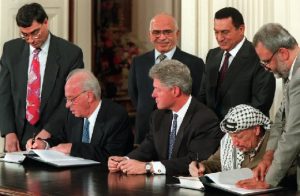 0928 PLO leader Yasser Arafat and Israeli Prime Minister Yitzhak Rabin sign a Mideast accord (AP Photo - Denis Paquin)