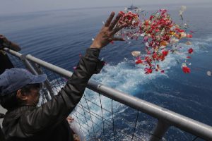 A relative sprinkles flowers for the victims of the Lion Air flight 610 where the airplane is believed to have crashed(AP Photo Tatan Syuflana)