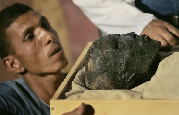 An archaeological worker looks across at the face of the linen-wrapped mummy of King Tut (AP Photo-Ben Curtis, Pool)