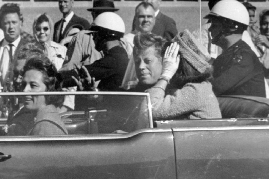 President John F. Kennedy waves from his car in a motorcade approximately one minute before he was shot in Dallas. (AP Photo-Jim Altgens, File)