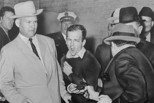 Lee Harvey Oswald reacts as Dallas night club owner Jack Ruby shoots him right in the corridor of Dallas police headquarters (AP Photo-Dallas Times-Herald)