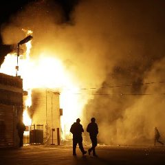 People walk away from a storage facility on fire after the announcement of the grand jury decision (AP Photo-Jeff Roberson)