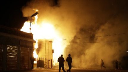 People walk away from a storage facility on fire after the announcement of the grand jury decision (AP Photo-Jeff Roberson)