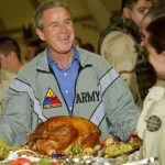 President Bush holds up a turkey platter for U S troops at Baghdad International Airport (AP Photo-Pablo Martinez Monsivais)