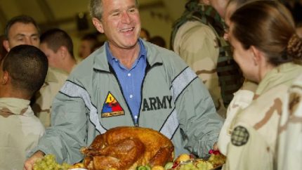 President Bush holds up a turkey platter for U S troops at Baghdad International Airport (AP Photo-Pablo Martinez Monsivais)