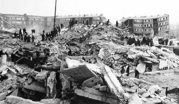 Teams of workers climb on a huge mound of rubble in quake-struck Leninakan, Armenia (AP Photo - Morten Hvaal)