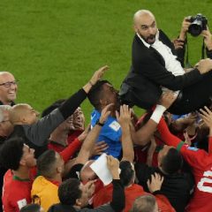 Moroccon players lift head coach Walid Regragui after the World Cup quarterfinal soccer match against Portugal in Doha, Qatar (AP Photo - Alessandra Tarantino)