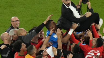 Moroccon players lift head coach Walid Regragui after the World Cup quarterfinal soccer match against Portugal in Doha, Qatar (AP Photo - Alessandra Tarantino)