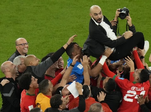 Moroccon players lift head coach Walid Regragui after the World Cup quarterfinal soccer match against Portugal in Doha, Qatar (AP Photo - Alessandra Tarantino)