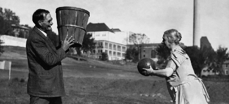 James Naismith holds the basket.