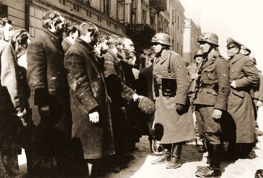 An SS sergeant interrogating Jews captured during the suppression of the Warsaw Ghetto Uprising