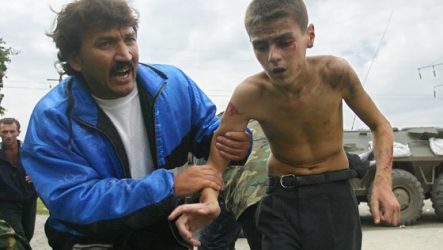 A man helps an injured boy running from a seized school in Beslan, North Ossetia